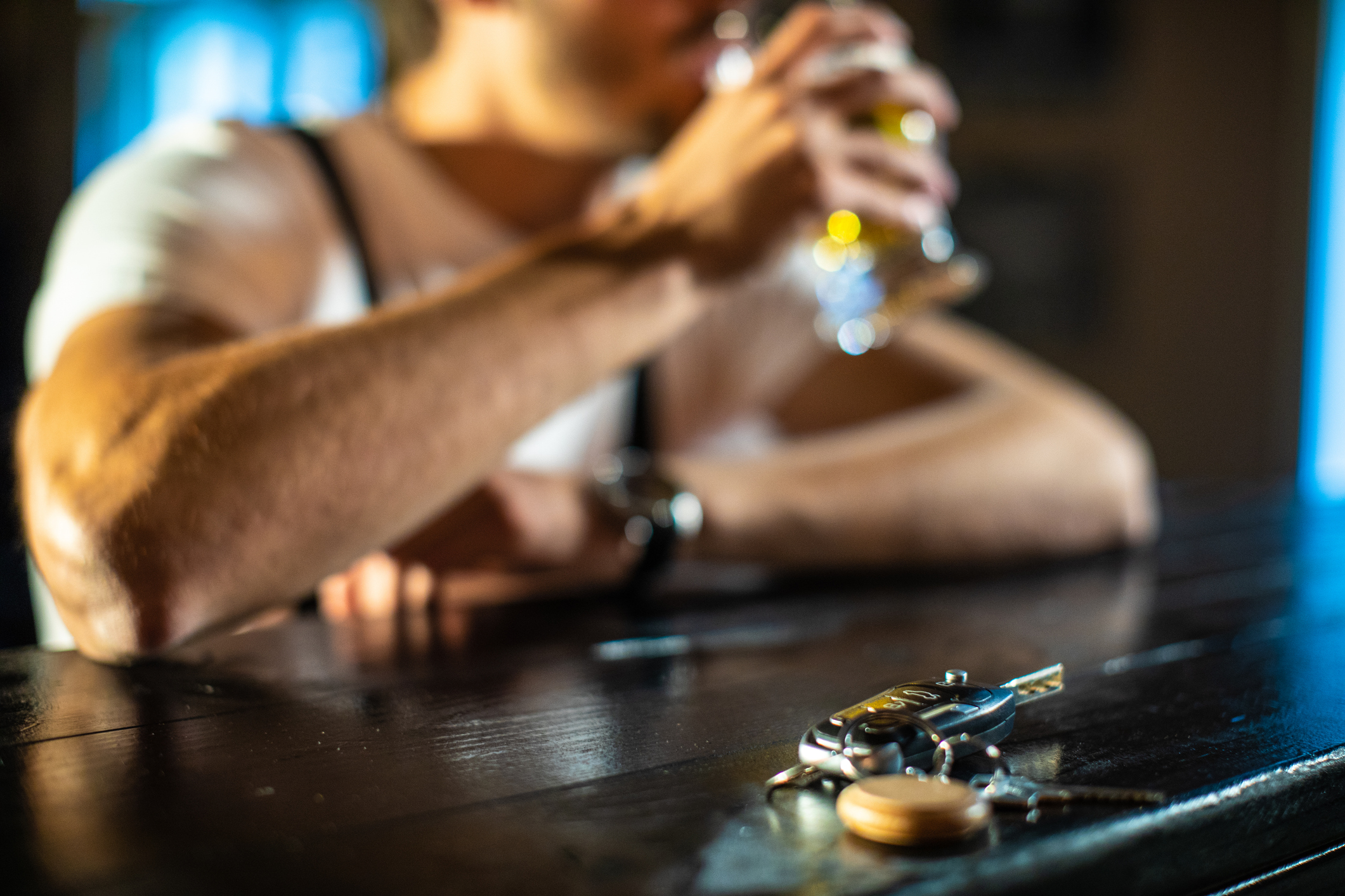 A man drinks with car keys nearby. If he's pulled over he will need a DUI lawyer Augusta GA trusts